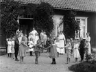 En skolklass med flickor, pojkar och kvinnor står i ring på en grusplan framför sin skola i Örserum.