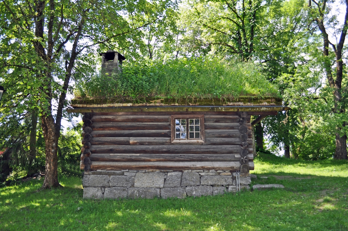 BERGE ELDHUS
Fra Berge, Miland i Tinn. Byggeår: Sen middelalder (1260). 

Eldhuset har opprinnelig vært en årestue med med ett rom. Laftemåten, formen på tømmeret og utformingen av dørpartiet daterer huset til senmiddelalder. Den nåværende takkonstruksjon og utskotet over døra synes å være av yngre dato. Stua har fått installert peis ant. på 16- eller 1700-tallet og små (blyglass-) vinduer, som sporene i veggen viser. Vinduene med tresprosser er ant. fra 1800-tallet.

Den gamle stua ble degradert til eldhus da gården fikk ny og større stuebygning. Eldhusets funksjon på gården kan sammenlignes med bryggerhusets og grovkjøkkenets i bynære strøk. Her ble det vasket, bakt og gjort opp kjøtt- og fiskemat. Navnet henspeiler på ilden, som var viktig for alle slike funksjoner og gjøremål.


THE BERGE FIREHOUSE
From: Berge, Miland in Tinn (Northeast Telemark). Constructed in the late Middle Ages. Rebuilt at the museum in 1962.

The firehouse has originally been an open-hearth cottage with one room. The way the timber is notched, the shape of the timber and the shape ov the doorway dates the house to the late Middle Ages. The present day roof construction appears to be of a newer date. The old cottage was downgraded to firehouse when a larger house was built on the farm.

The function of the firehouse can be compared to theat of the wash-house and the scullery in urban areas. Here there would be washing, baking and preparation of meat and fish. The name indicates the fire, which was important for all such duties and tasks.