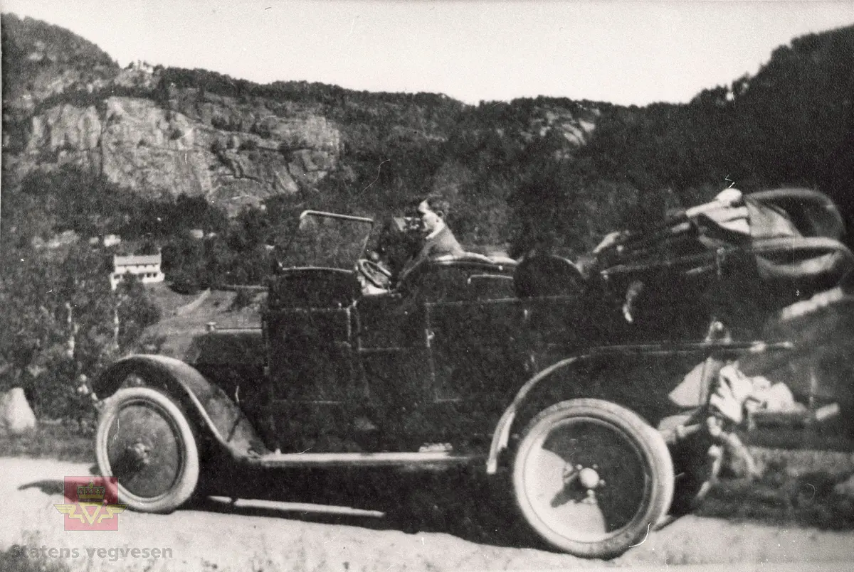 Gamlevegen ved Årøy i Sogndal på i byrjinga av 1930-åra.

Bilar og folk er ukjente.