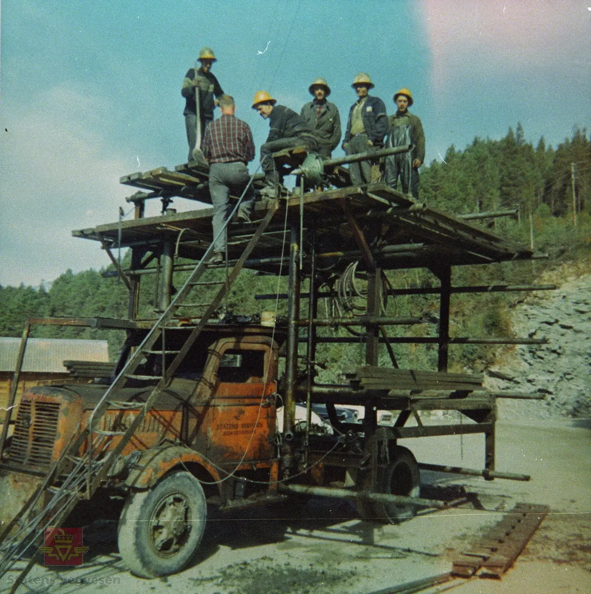 Etter gjennomslaget 2. september 1968 på den 813 meter lange Kjøshammartunnelen på riksveg 60 i Hornindal kommune. 

6 mann på ein arbeidsplattform, bygd på ein FWD lastebil for bruk til arbeid i tunnel.

Bilen er merka "Statens vegvesen Sogn og Fjordane"
14.04.2023: Lastebilen ser ut til å være en FWD ca. 1950 modell. (Opplysninger fra Jo-Olav Bakken). 
Se Relasjon til gjenstandsnummer NVM G-02439 lenger ned på siden.