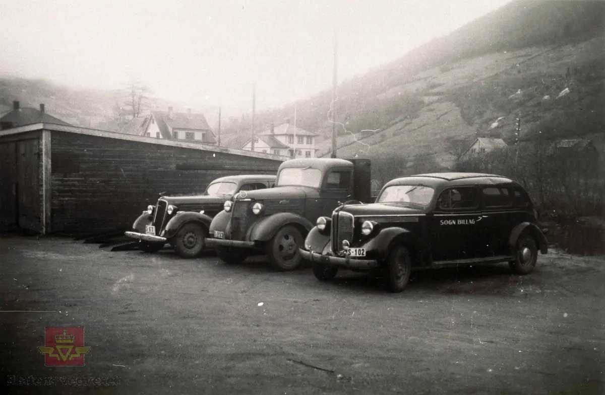 Ved "Stadladn" på Vikøyri i Vik kommune i 1946. 
Ein Dodge rutevogn frå Sogn Billag med kjenneteikn S-102, ein Chevrolet lastebil med kjenneteikn S-233 og Nash rutevog med kjenneteikn S-67.

03.01.2023: S-102 er Dodge 1937-38 7-seter med soltak, montert på Strømmens Værksted. S-233 er en Chevrolet 1938.  S-67 er en Chevrolet 1935. 
(Opplysninger til kjøretøyene fra Ivar Erlend Stav).