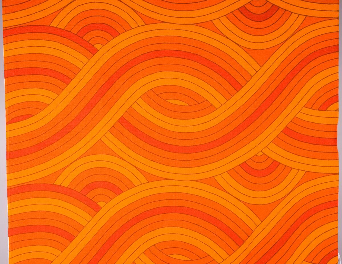 Textiltryck med vågliknande symmetriskt mönster i orange och gult.