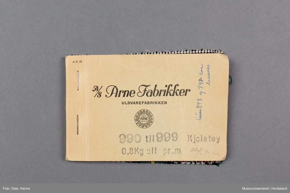 Mappe med rektangulære stoffprøver av vevd ullstoff frå ullvarefabrikken ved Arne Fabrikker. Desse er til kjoletøy i houndstooth/tartan-mønster.