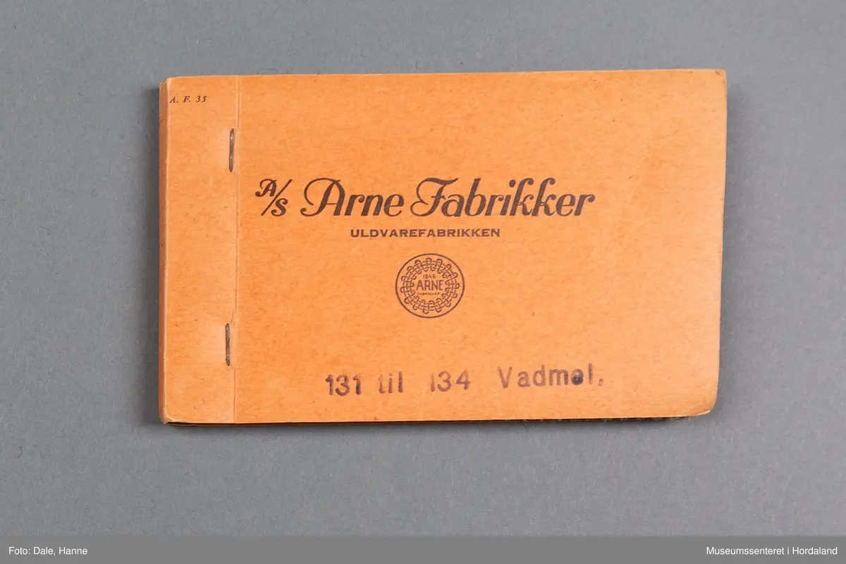 Mappe med rektangulære stoffprøver av vevd ullstoff frå ullvarefabrikken ved Arne Fabrikker. Desse er til vadmelsstoff.