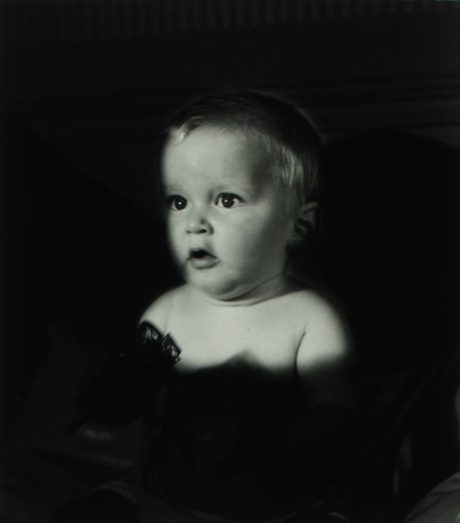 Portrett av en baby mot sort bakgrunn.