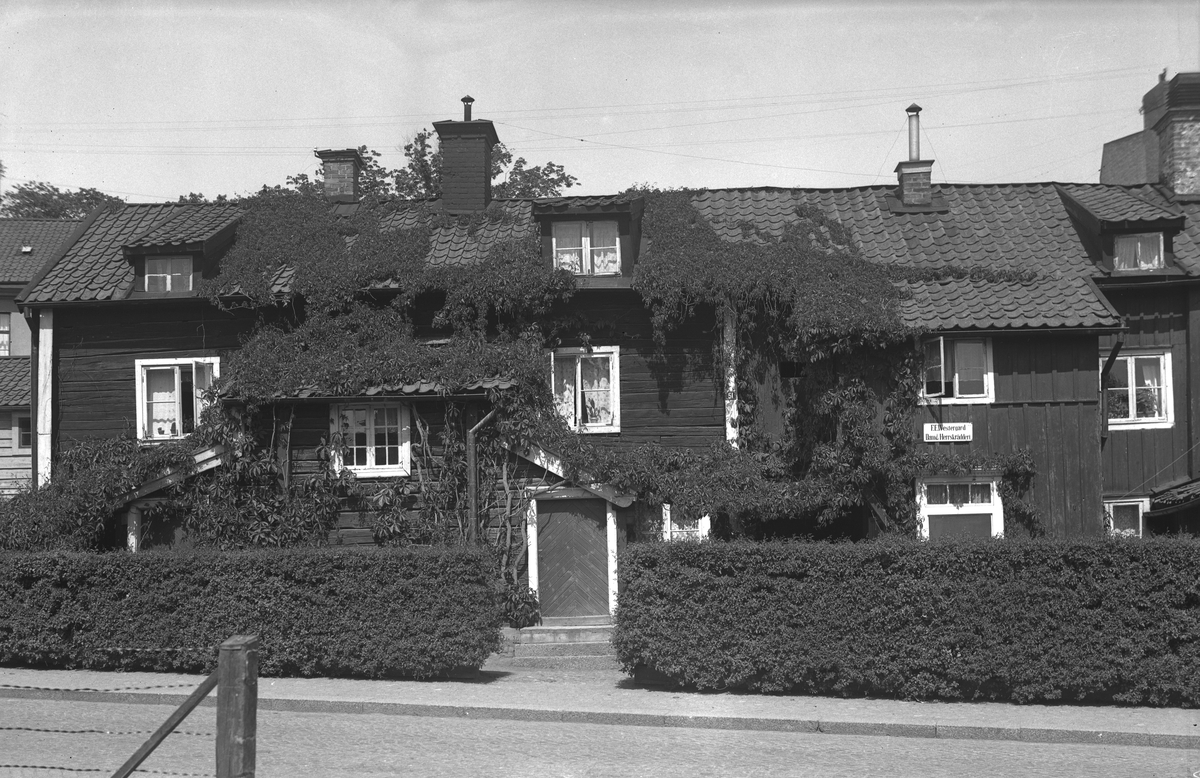 Denna fantasifulla och av ålder präglade timmerlänga, som fram till 1951 bar adressen Nygatan 51 i Linköping, uppfördes enligt senare rön först 1784 och förblev relativt intakt så länge det bestod på platsen. I gården växte upplysningsvis Edvard Wavrinsky upp, bland många positioner Sveriges första förbundschef för det enade IOGT. Byggnaden flyttades till friluftsmuseet Gamla Linköping nämnda året 1951. Odaterad bild från tidigast 1934 då Fredrik Emil Westergård etablerade sitt annonserade skrädderi i gården.