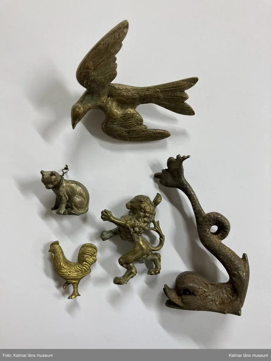 KLM 28629:124. Metallfigurer, halvfabrikat, samling. Av olika metallegeringar. Samling av gjutna tredimensionella metallfigurer i form av olika slags djur och människor. Merparten är dekorativa delar till exempelvis ljusstakar, skålar, fat, kannor, stämplar etc. Figurerna är gjutna och bearbetade av guldsmeden.