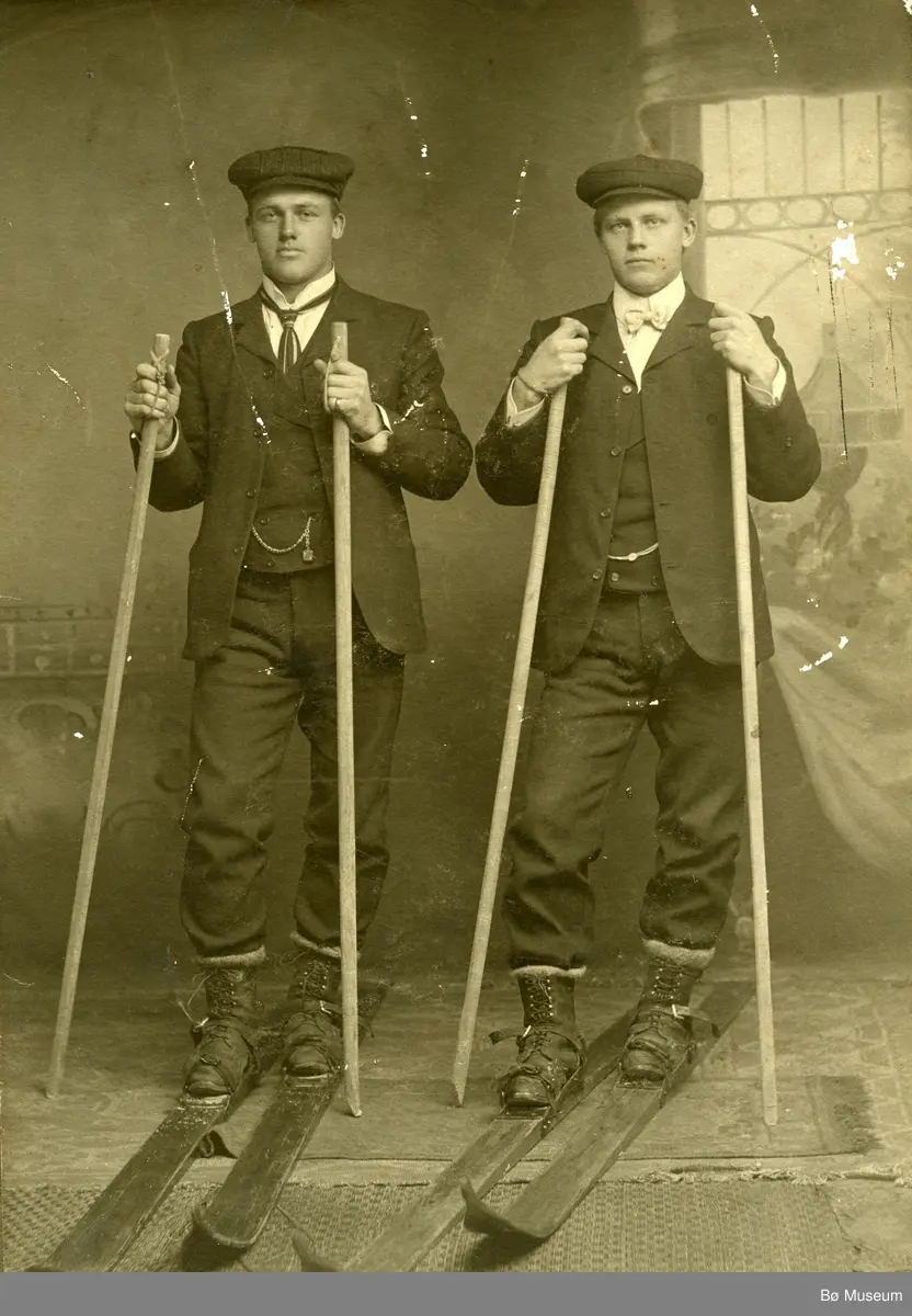 Helland Brothers, Knut G. Helland t.v. og Gunnar G. Helland t.h. på ski inne i eit fotoatelier.