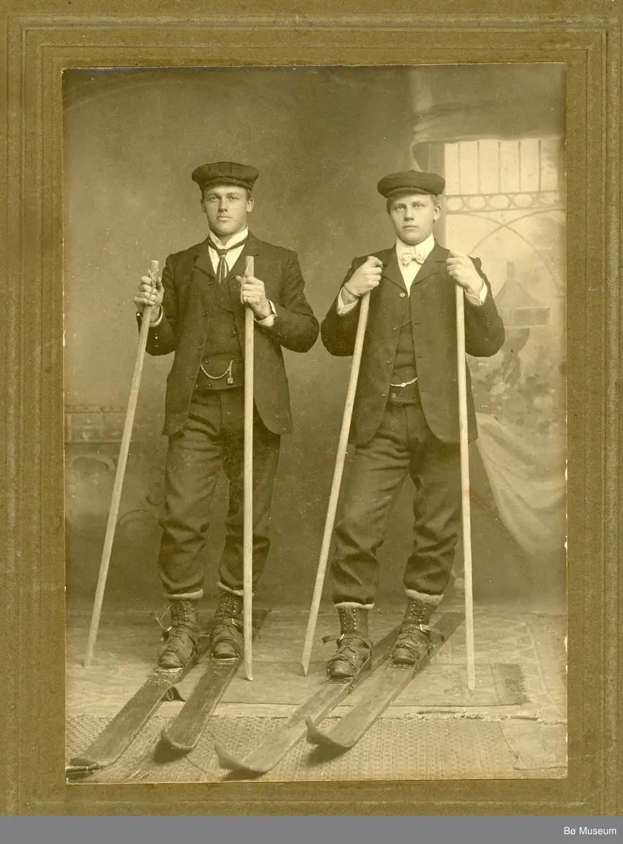 Helland Brothers, Knut G. Helland t.v. og Gunnar G. Helland t.h. på ski inne i eit fotoatelier.