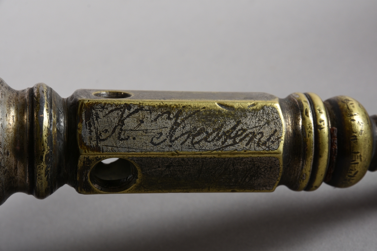 Sigarkutter/-kniv i to delar - ein kuttedel og ein behaldar.
Kuttedelen er eit sekskanta røyr med tre opningar av ulik storleik i nedste enden. På toppen av røyret eit stempel med fjøring og ein sylindrisk kuttekniv i andre enden. Kuttedelen er skrudd til ein sirkelrund base i tre som og fungerer som lokk over ein boks i dreid tre, til oppsamlig av avkutt frå sigarkniven. Sigaren settast inn i eit av dei tre hola, alt etter storleik, stempelet trykkast ned og kuttar tuppen av sigaren før bruk. Behaldaren er sylindrisk med profilkant på den øvre delen, med ein base med større diameter og profildreiing.