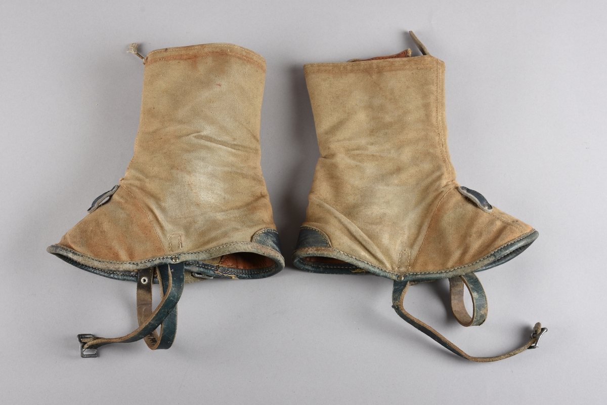 Eit par gamasjar for vaksne. Gamasjane er sydd i kraftig lerret. Påsydd naturfarga lêr besetning på innsida ved hæl- og tåparti  og over saumar. På utsida farga lêr på kanten nede, i hemper, reimer og som hælkappe.
Gamasjane har lukking på utsida med snor trædd gjennom seks par metall hekter og knytt oppe. I nedkant er og lukking med lêrstropp og metallspenne.