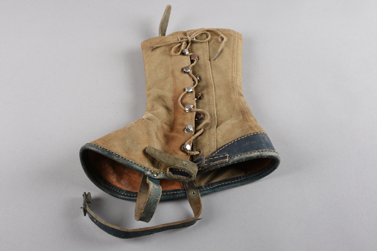 Eit par gamasjar for vaksne. Gamasjane er sydd i kraftig lerret. Påsydd naturfarga lêr besetning på innsida ved hæl- og tåparti  og over saumar. På utsida farga lêr på kanten nede, i hemper, reimer og som hælkappe.
Gamasjane har lukking på utsida med snor trædd gjennom seks par metall hekter og knytt oppe. I nedkant er og lukking med lêrstropp og metallspenne.