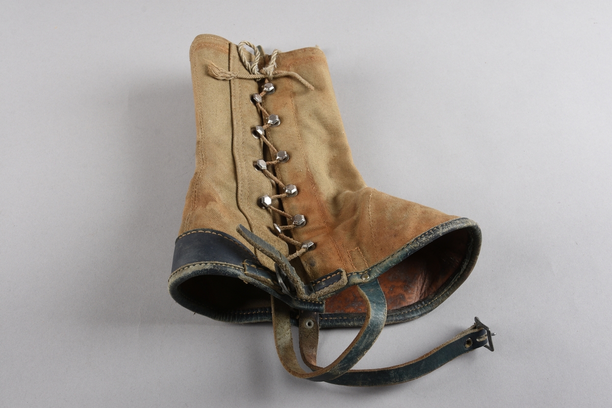 Eit par gamasjar for vaksne. Gamasjane er sydd i kraftig lerret. Påsydd naturfarga lêr besetning på innsida ved hæl- og tåparti  og over saumar. På utsida farga lêr på kanten nede, i hemper, reimer og som hælkappe.
Gamasjane har lukking på utsida med snor trædd gjennom seks par metall hekter og knytt oppe. I nedkant er og lukking med lêrstropp og metallspenne.