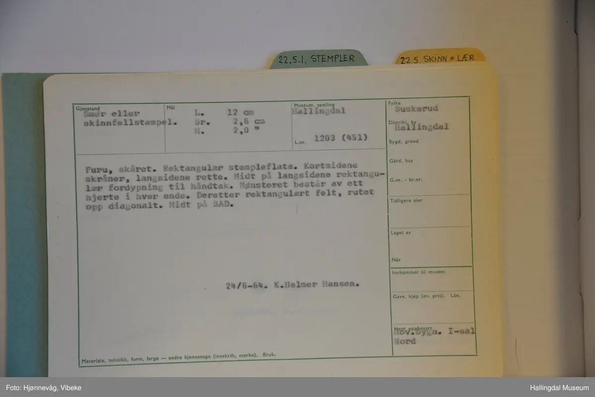 Rektangulær stempelflate. Kortsidene skråner, langsidene rette. Midt på langsidene rektangulær fordypning til håndtak. Deretter rektangulært felt rutet opp diagonalt. Hjerter på hver side med spiss mot kanten. Felt i midten med bokstavene BAD.
