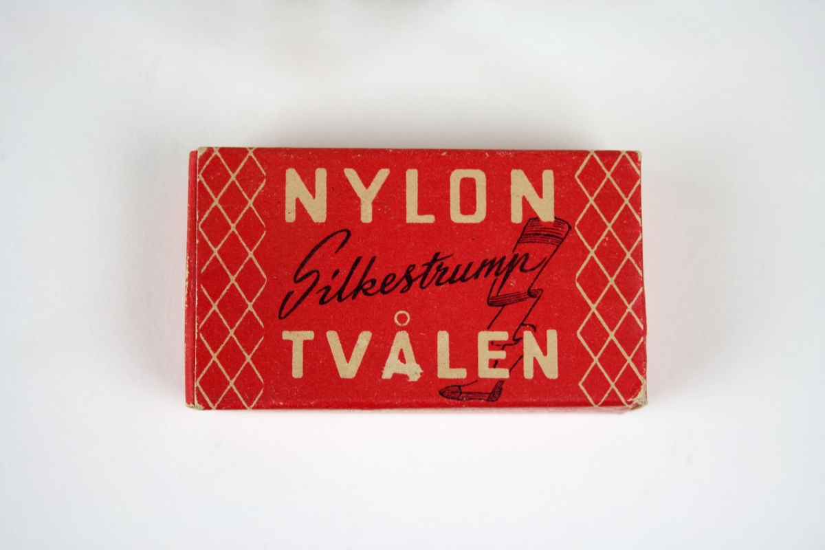 Tvål avsedd för tvätt av nylonstrumpor i originalförpackning. 
Tvålen består av gjuten tvålmassa med text i relief: NYLON SILKE. 
Pappersförpackningen är röd med rutmönster i beige och en tecknad silkesstrumpa i svart samt beige och svart text. På baksidan står en bruksanvisning.
