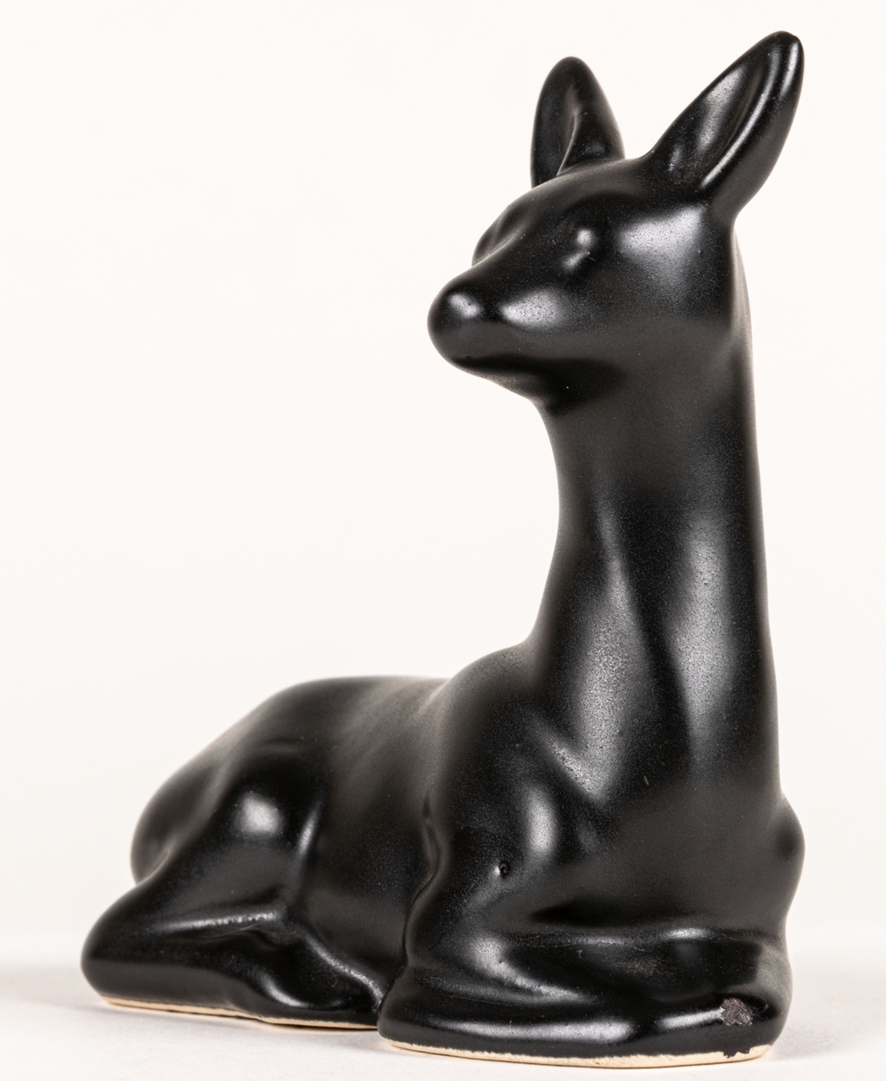 Figurin, svart mangania, föreställande ett liggande rådjur.