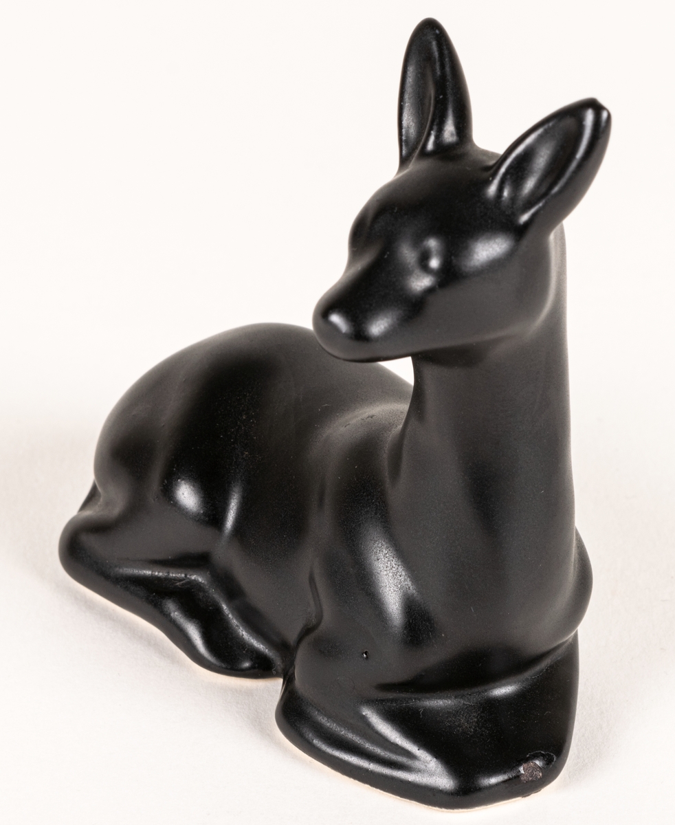 Figurin, svart mangania, föreställande ett liggande rådjur.