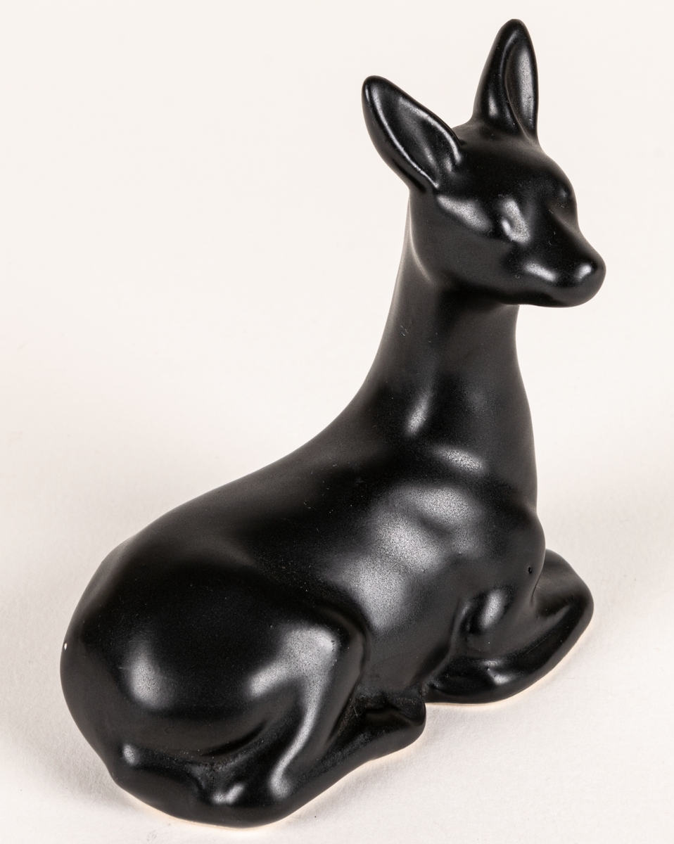 Figurin, svart mangania, föreställande ett liggande rådjur.