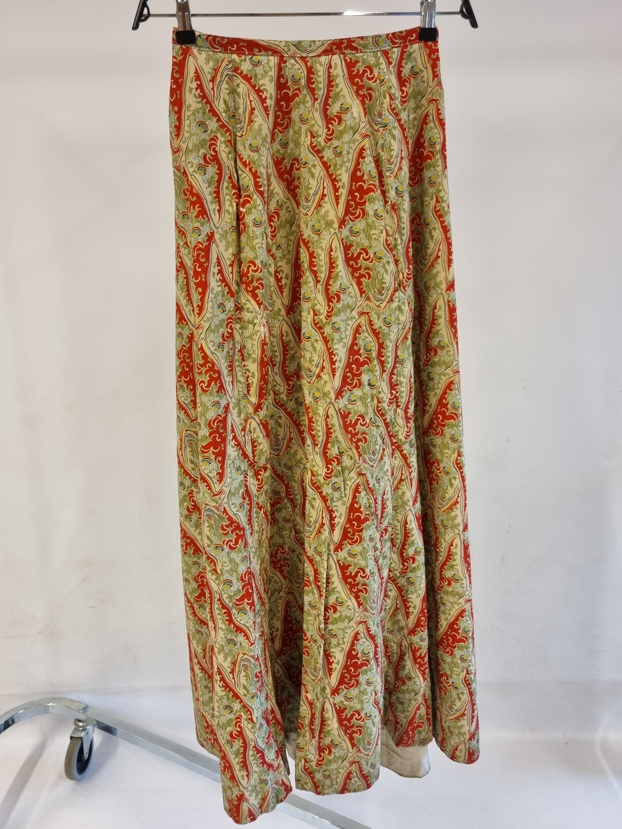 Jakke: Halslinning, lange ermer, forknappet,spiler,smale fløyelsbånd til pynt. Foret.

Skjørt: Linning, volang, foret.