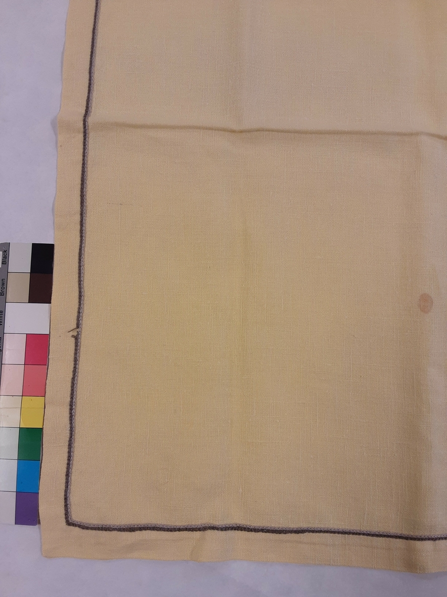Duken er av lin eller halvlin og brodert med broderigarn sannsynligvis av bomull i ulike nyanser av sort og grått.