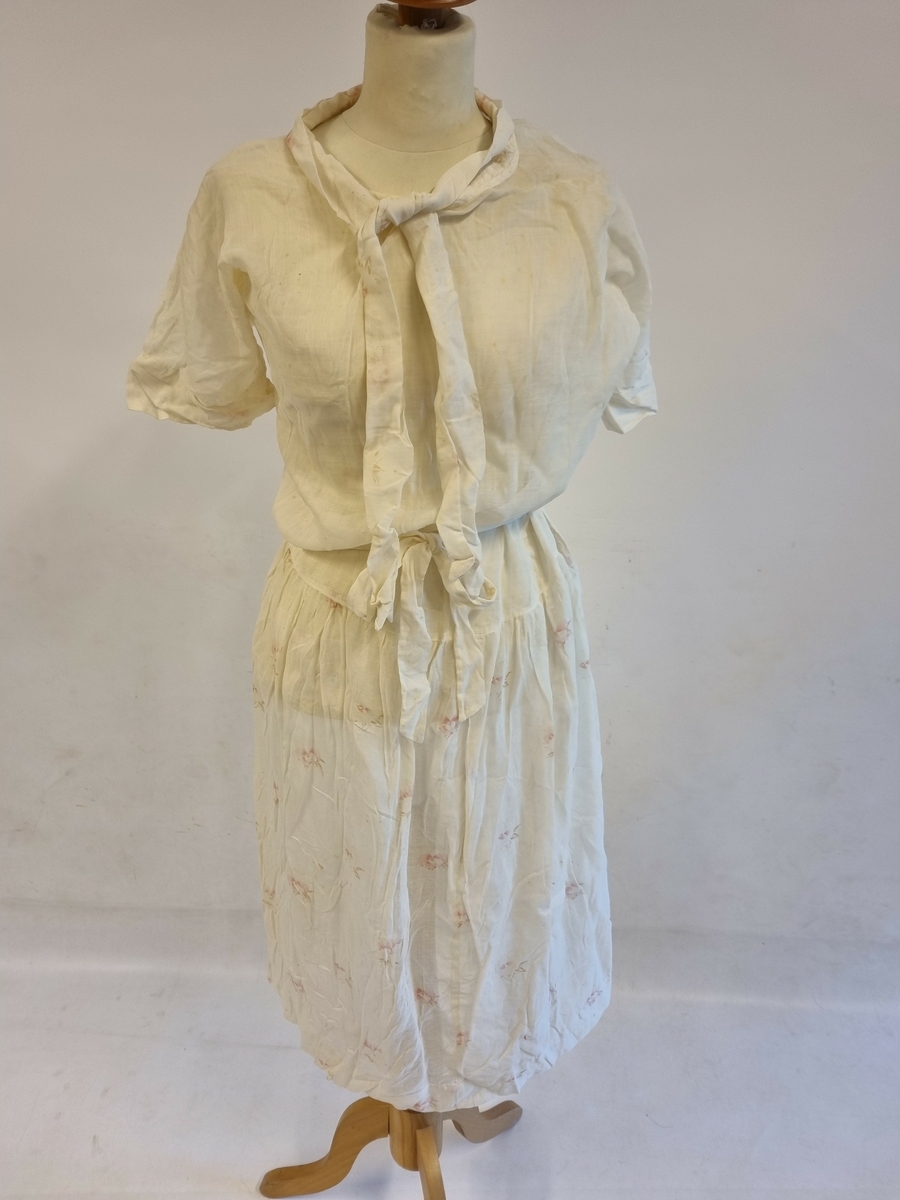 Sommerlett med knytekrave, korte ermer, langt liv, rynkeskjørt og knytebelte.