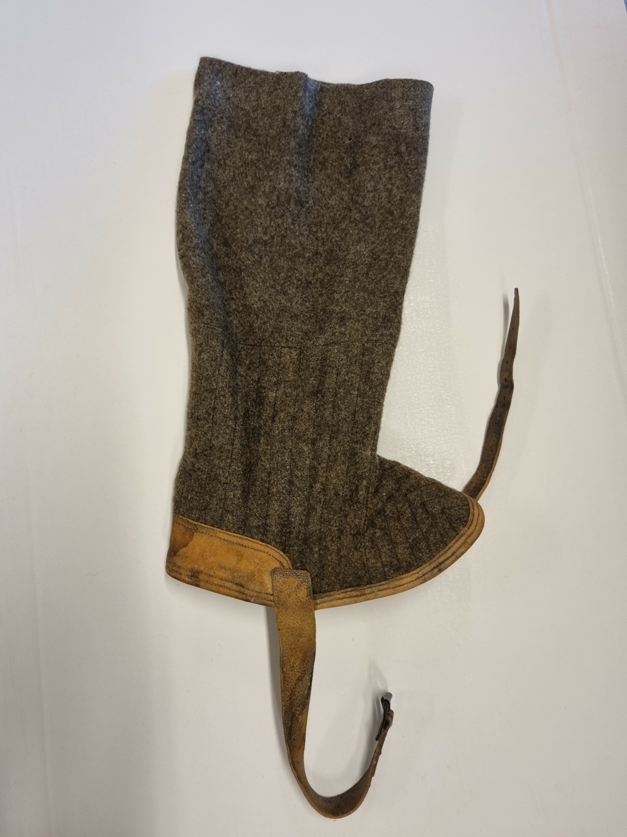 Høy gamasje i vadmel kantet med skinn. Skinnreimer.