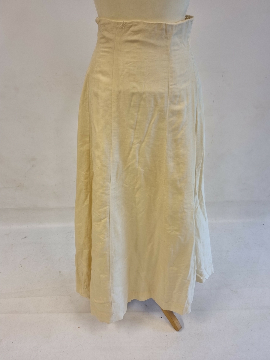 Langt skjørt med litt slep og køeffekt. Lukking bak. Fòret.