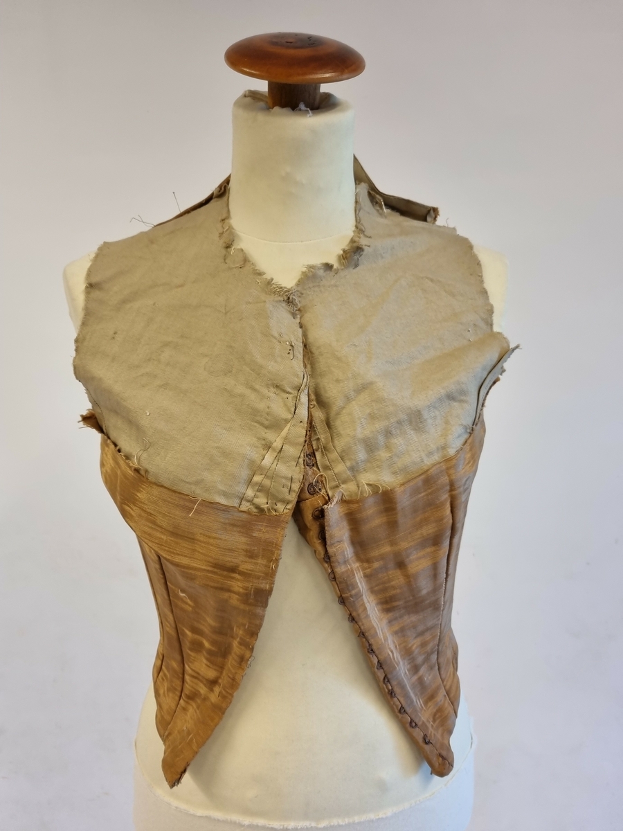 Et delvis sundklippet kjoleliv i silkerips. Helfòret og med spiler.