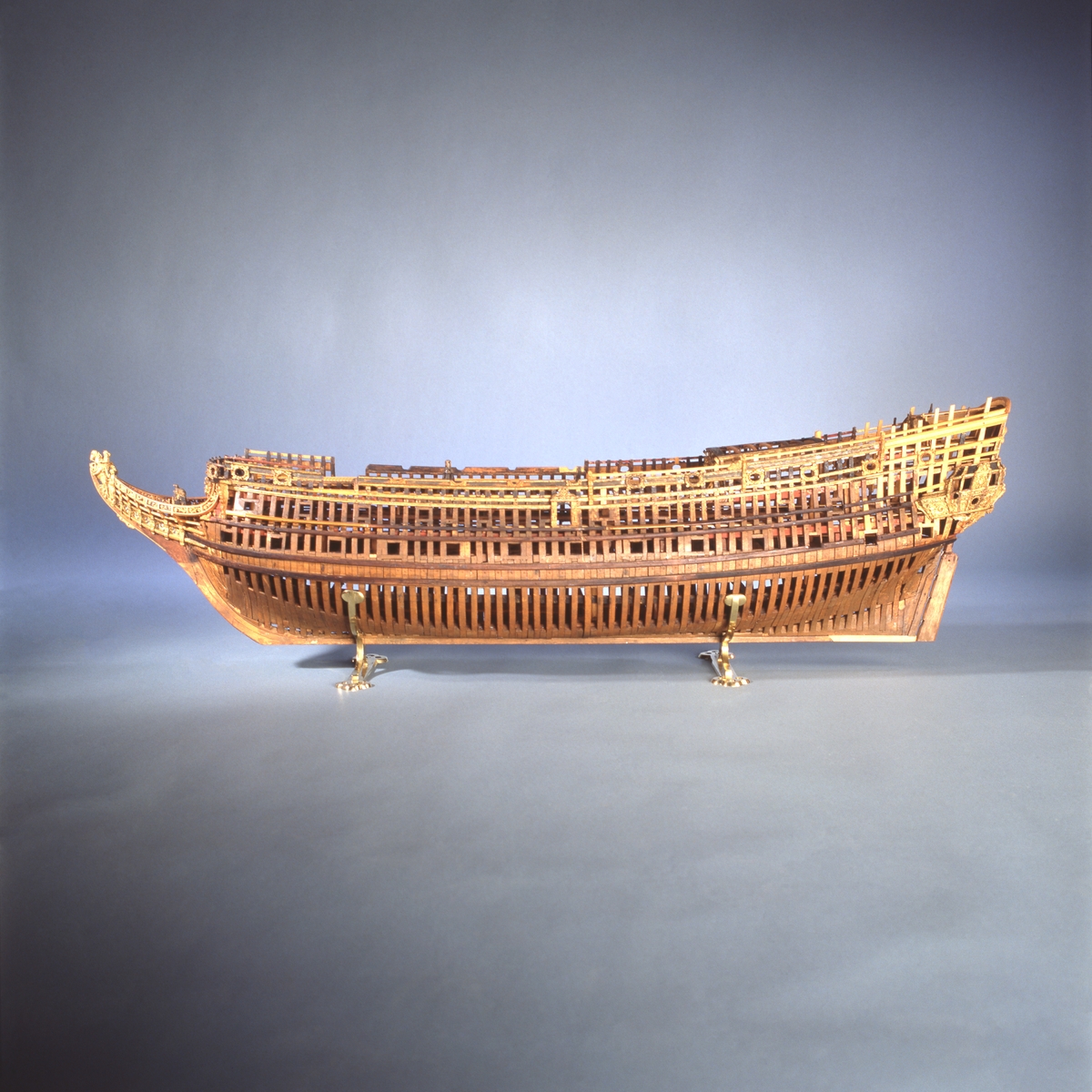 This unplanked model of a three-decker can be dated to c. 1660 and is one of the world's oldest models of a warship. Although not definitively identified, recent research links it to the Swedish ship *Riksäpplet*, designed by the English master shipwright Francis Sheldon and launched in 1661.     
The model was possibly made for Sheldon, who came to Sweden in 1659. He was one of a number of English shipwrights employed by the Swedish crown during the period. Previously, most Swedish warships had been built in the Dutch style.

From around 1660, the English Royal Navy’s administrators commissioned models that were accurately detailed and true to scale. These miniatures, which came to be called Navy or Admiralty Board models, had an unplanked lower hull to emphasise the shape of the underwater body. 

The model was restored by rear-admiral Jacob Hägg in the late 1890s. Missing parts have been reconstructed using lighter coloured wood.

3D model produced by Adam de Kaminski and Vasilis Haroupas for SMTM, 2023
