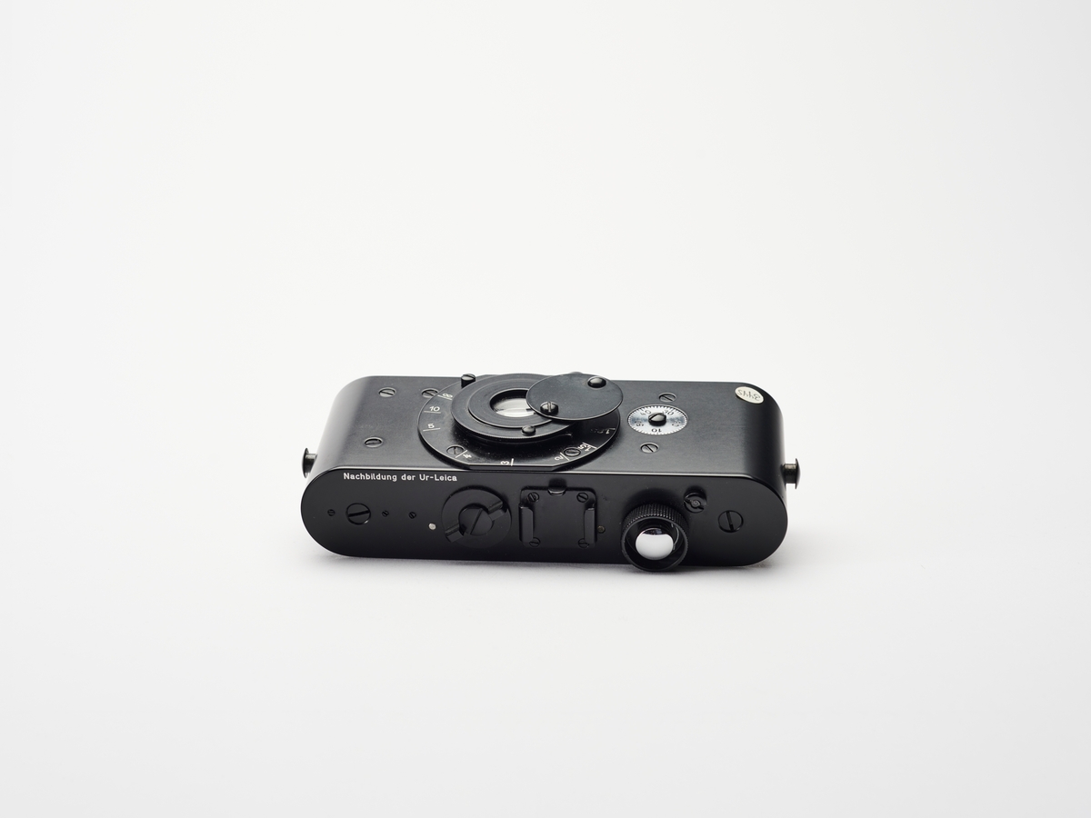 Dette er en Ur-Leica replika. Prototypen ble designet av Oscar Barnack i 1913. Replikaer ble produsert av Leitz slik at bl.a. museer kunne vise og fortelle om dette kameraets betydning for utviklingen innen kamerateknologi og fotohistorie.
Det første Leica-kamera, prototypen Ur-Lecia ble produsert i 1914, men ikke lansert før i 1923, grunnet første verdenskrig. Den første serien ble kalt 0-serie. På denne tiden var kameraene store, tunge og ofte vanskelig å håndtere. Oppfinner og fotograf Oskar Barnack (1879–1936) ved det tyske Ernst Leitz Optische Werke i Wetzlar, var både astmatiker og ivrig fjellklatrer og så derfor et behov for å lage et lettere og enklere kamera. Han klarte å kombinere et lite format med god optikk og konstruerte det som kom til å bli en av de mest populære kameraene gjennom tidene. Negativformatet var en doblet bildebredde på datidens vanlige kinofilm, som var 18 x 24 millimeter. Ved å bruke filmen horisontalt i stedet for vertikalt ble formatet til 24 x 36 millimeter.
Ernst Leitz lanserte Leica 1 på vårmessen i Leipzig i 1924. Navnet Leica er en komibinasjon av av ordene «Leitz» og «Camera». Leica 1 ble tatt godt imot av både amatører og profesjonelle fotografene som Robert Capa, André Kertész og Henri Cartier-Bresson.