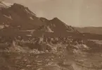 Fotografi från första svenska Antarktisexpeditionen 1901-1904. Motiv av packning som lastats av i ett isigt bergslandskap.