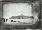 Fotografi från första svenska Antarktisexpeditionen 1901-1904. Motiv av män med släde och hundspann med berg i bakgrunden.