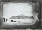 Fotografi från första svenska Antarktisexpeditionen 1901-1904. Motiv av män med hundsläde i snölandskap vid berg.