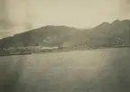 Fotografi från expedition till Peru 1920. Vy över hav, berg och stad vid havet.