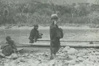 Fotografi från expedition till Peru 1920. Motiv av man och pojkar vid flod i djungeln.