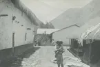Fotografi från expedition till Peru 1920. Motiv av en pojke som står på en liten gata i en bergsby.