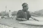 Fotografi från expedition till Peru 1920. Motiv av man som bär kanot vid flod.