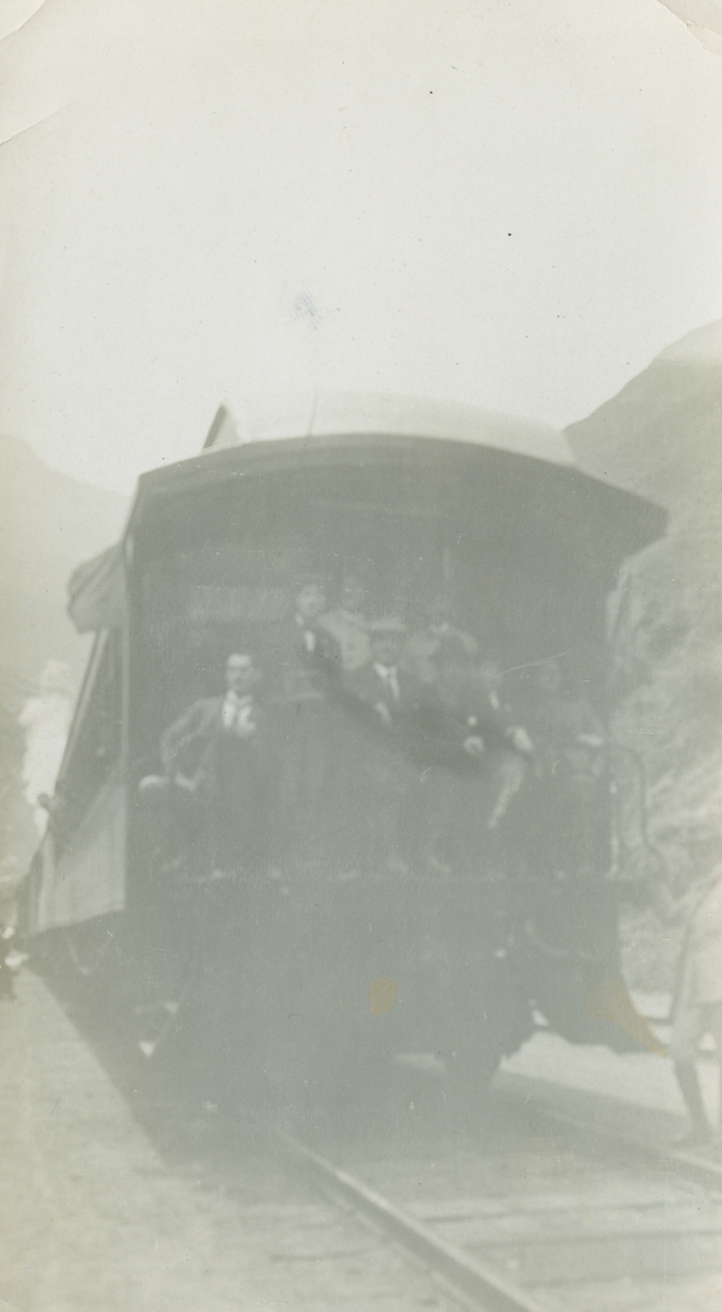 Fotografi från expedition till Peru 1920. Motiv av flera expeditionsdeltagare som poserar längst bak på ett tåg.