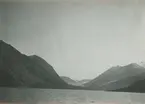 Fotografi från expedition till Östgrönland 1929. Dansk-svensk expedition under ledning av Lauge Koch. Svenska deltagare: Oscar Kulling och Helge Backlund. Vy över hav, bergslandskap och himmel.