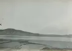 Fotografi från expedition till Östgrönland 1929. Dansk-svensk expedition under ledning av Lauge Koch. Svenska deltagare: Oscar Kulling och Helge Backlund. Vy över bergslandskap, vatten och himmel.