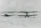 Fotografi från svenska undsättningsexpeditionen 1928. Motiv av två flygplan i snön. Det ena planet är av typen Moth, de andra av typen Klemm-Daimler.