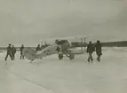 Diverse bilder från Fred Goldbergs samling. Människor och flygplan i istäckt landskap i Hägernäs, 1922.