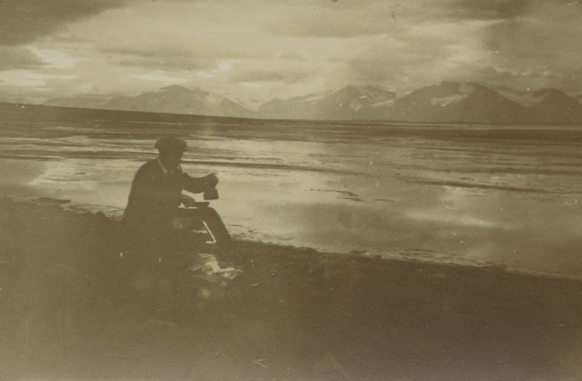 Fotografi från expedition till Spetsbergen. Motiv av expeditionsdeltagare som dricker kaffe vid vatten.