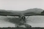 Fotografi från låda märkt Bernt Balchen. Balchen var norsk-amerikansk flygare, polarforskare och militär. Motiv av flygbåt i vatten framför berg.