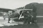 Fotografi från låda märkt Bernt Balchen. Balchen var norsk-amerikansk flygare, polarforskare och militär. Motiv av två män och två kvinnor bredvid flygbåt som ligger i vattnet.