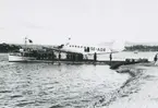 Fotografi från låda märkt Bernt Balchen. Balchen var norsk-amerikansk flygare, polarforskare och militär. Motiv av flygbåt och båt vid strand.