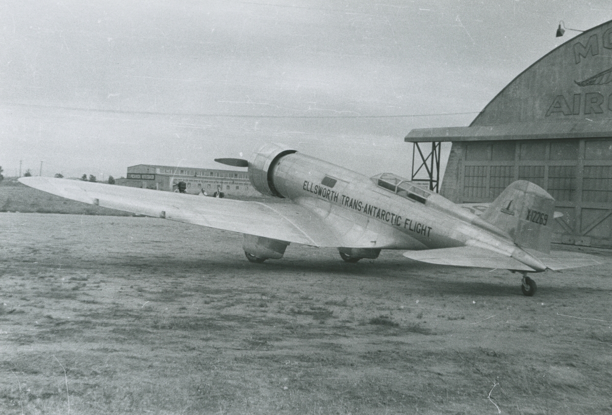 Fotografi från låda märkt Bernt Balchen. Balchen var norsk-amerikansk flygare, polarforskare och militär. Motiv av flygplanet Polar star utanför flyghangar. På planet står texten: "Ellsworth Trans-Antarctic Flight".