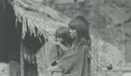 Fotografi från Peruexpedition 1920. Motiv av kvinna som håller i barn vid hydda.