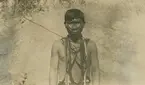 Vykort från Peruexpedition 1920. Porträtt av barbröstad och ansiktsmålad man med smycken runt halsen.