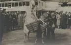 Fotografi från Stockholmsutställningen 1930. Motiv av fruktförsäljerska som rider på åsna.